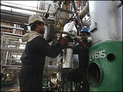Iranian oil workers seen at Tehran’s oil refinery, Iran, Nov. 17, 2007. Although OPEC has traditionally tied its price of oil to U.S. dollars, Iran has announced it has shifted sales of its oil to euros and yen